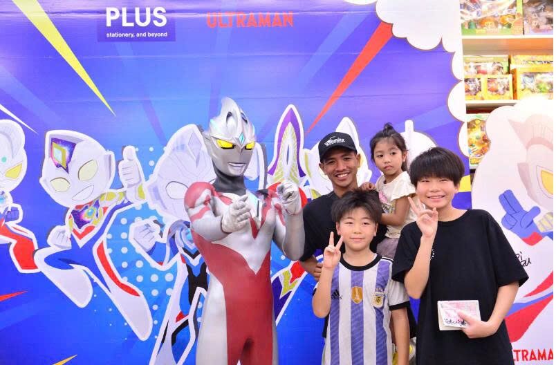 Families posing together with Ultraman at the Japanese Ultraman superhero performance event at FAHASA Tan Dinh Bookstore.
