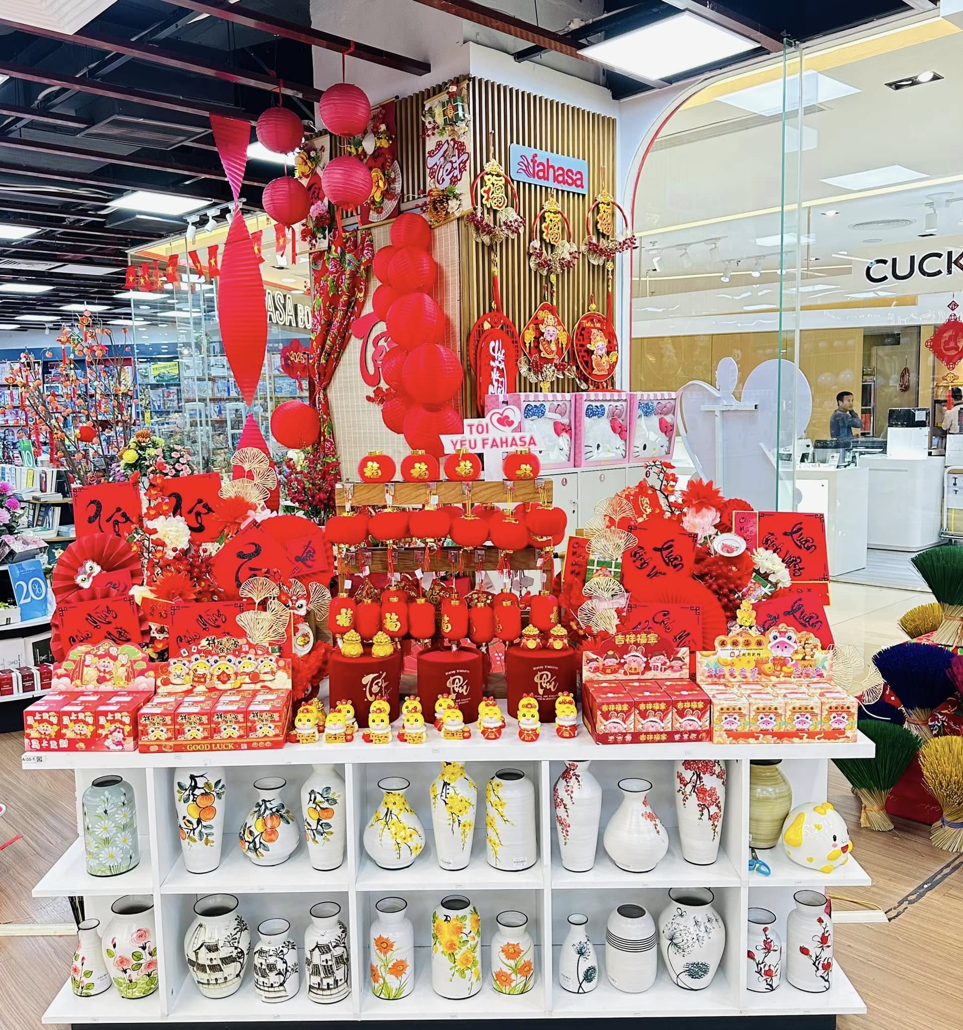 Combo trang trí Tết đầy đủ gồm đồ treo Tết, bao lì xì, hoa mai đào, mô hình Tết và backdrop mini, thiết kế đồng bộ màu sắc. Nguồn: FAHASA